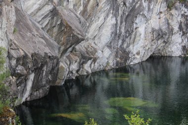 Bir çam ormanı içinde mermer duvarlar ile göl