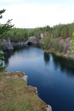 Bir çam ormanı içinde mermer duvarlar ile göl