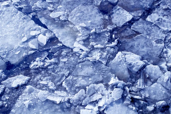 Texture of blue ice pieces on surface of the water