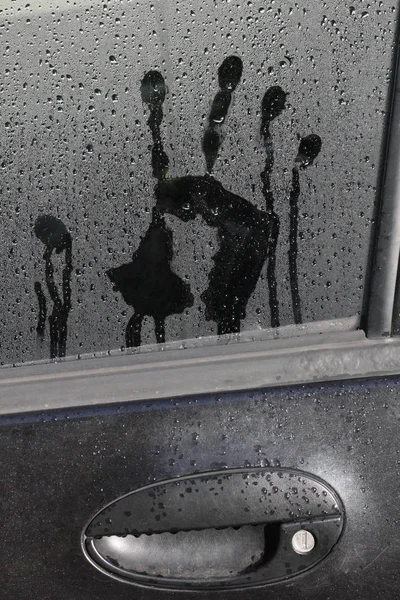 Imprint of a male hand on a car glass