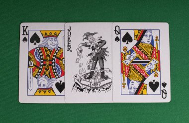 Yeşil bezli bir masaüzerinde kartlar ve kağıt dolarlar