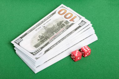 Yeşil bezli bir masada zar ve kağıt dolar