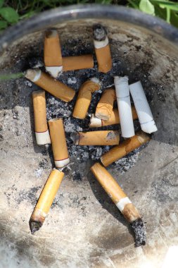 Demir kasede eski, kirli sigara izmaritleri.