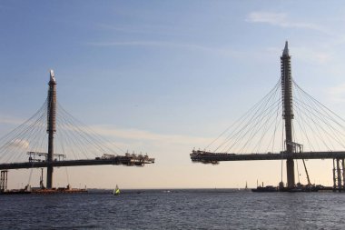 Geniş bir nehir boyunca büyük bir köprü inşa ediliyor.