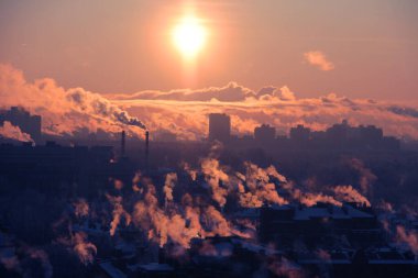Gün batımında sanayi binaları ve sis. Küresel ısınma sorunu