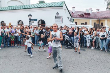 1 Eylül 2018 Minsk Beyaz Rusya sokak Şenlikleri duran bir adam bir mikrofon ile akşam şehir ve bir grup çocuk bir grup insan önünde dans ediyor.