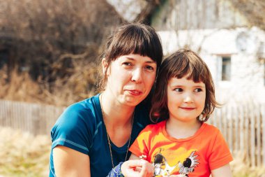 15 Nisan 2018, Krevo, Beyaz Rusya, Beetle iz: arka plan üzerinde doğa manzaralı yolda annesiyle gülümseyen kız portresi