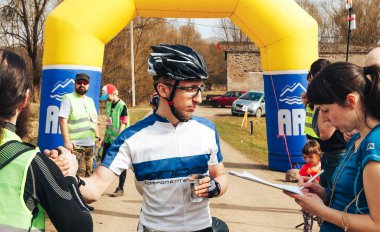 15 Nisan 2018, Krevo, Beyaz Rusya, Beetle iz: yakışıklı genç bisikletçi yarış yöneticileri için konuşmaya kask içinde