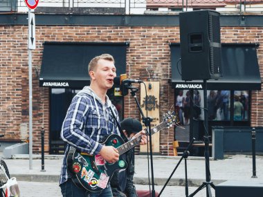 21 Temmuz 2018 - Minsk, Beyaz Rusya: adamla sokakta mikrofona gitar şarkı söyler