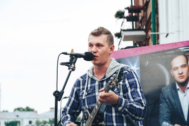 21 Temmuz 2018 - Minsk, Beyaz Rusya: adamla sokakta mikrofona gitar şarkı söyler