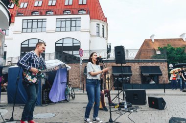 21 Temmuz 2018 - Minsk, Beyaz Rusya: mikrofon standları önünde birçok insan sokakta kadınla