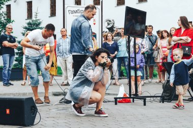 21 Temmuz 2018 - Minsk, Beyaz Rusya: Street yürür. Bir grup insan önünde sokakta kız kamera ile fotoğraf çeker