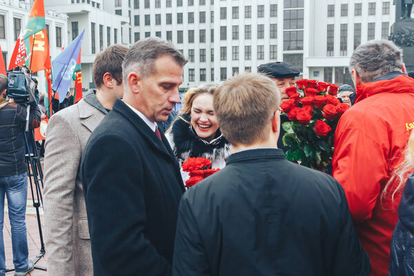 November 7, 2018 - Minsk, Belarus: Anniversary of Great October Socialist Revolution, group of people standing on square with flags and chatting