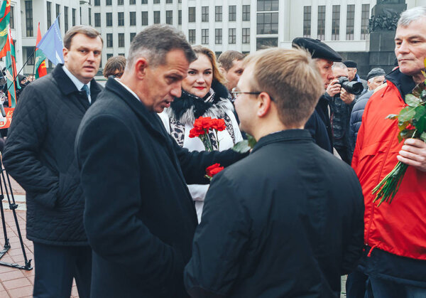 November 7, 2018 - Minsk, Belarus: Anniversary of Great October Socialist Revolution, group of people standing on square with flags and chatting