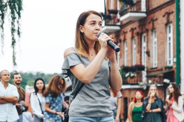 21 Temmuz 2018 - Minsk, Beyaz Rusya: mikrofon standları önünde birçok insan sokakta kadınla