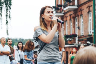 21 Temmuz 2018 - Minsk, Beyaz Rusya: mikrofon standları önünde birçok insan sokakta kadınla