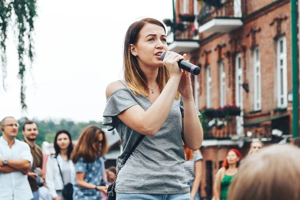 21 Temmuz 2018 - Minsk, Beyaz Rusya: mikrofon standları önünde birçok insan sokakta kadınla