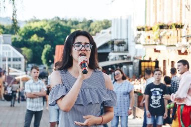 21 Temmuz 2018 - Minsk, Beyaz Rusya: mikrofon standları önünde birçok insan sokakta kadınla