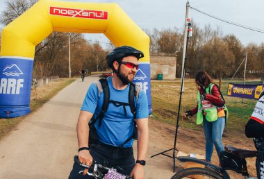 15 Nisan 2018 - Krevo, Beyaz Rusya: Beetle Trail Krevo, Bisiklet ayakta şişme arch yakınındaki adamla