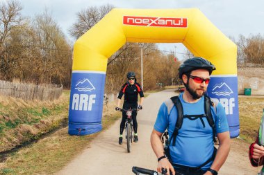 15 Nisan 2018 - Krevo, Beyaz Rusya: Beetle Trail Krevo, Bisiklet ayakta şişme arch yakınındaki adamla