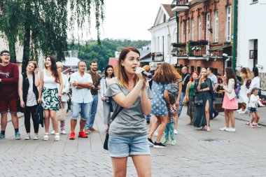 21 Temmuz 2018 - Minsk, Beyaz Rusya: mikrofon standları önünde birçok insan sokakta kadınla