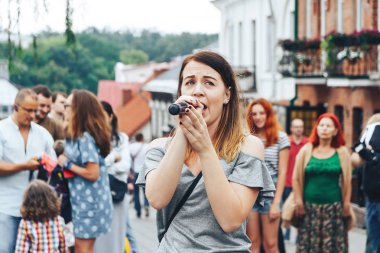 21 Temmuz 2018 - Minsk, Beyaz Rusya: mikrofon standları önünde birçok insan sokakta kadınla