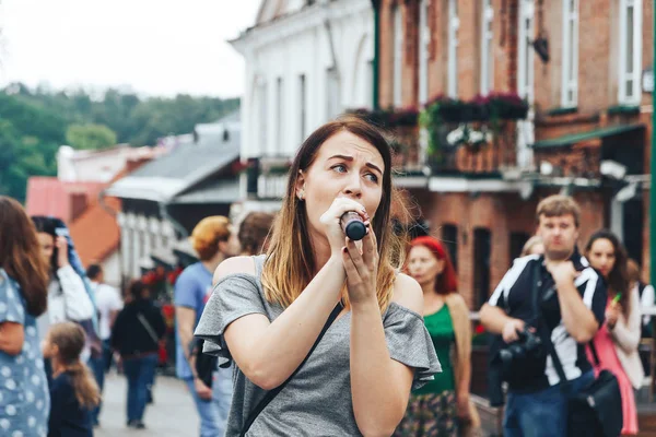 21 Temmuz 2018 - Minsk, Beyaz Rusya: mikrofon standları önünde birçok insan sokakta kadınla
