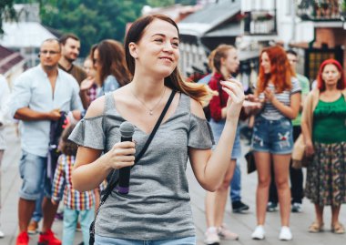 21 Temmuz 2018 - Minsk, Beyaz Rusya: mikrofon standları önünde birçok insan sokakta kadınla