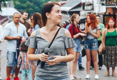 21 Temmuz 2018 - Minsk, Beyaz Rusya: mikrofon standları önünde birçok insan sokakta kadınla