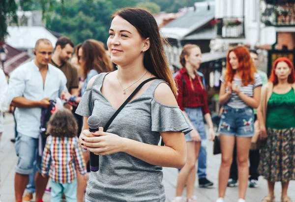 21 Temmuz 2018 - Minsk, Beyaz Rusya: mikrofon standları önünde birçok insan sokakta kadınla