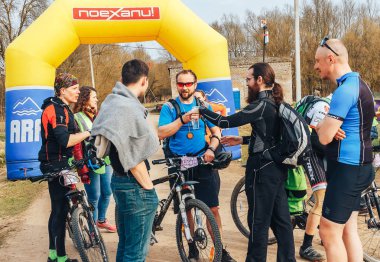 15 Nisan 2018 - Krevo, Beyaz Rusya: Böcek Krevo, şişme arch yakınındaki Bisikletleri ile ayakta erkekler iz