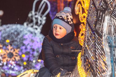 29 Aralık 2018 - Minsk, Beyaz Rusya: yeni yıl kutlamaları kasaba meydanında. küçük çocuk üzerinde parlayan atın üzerinde oturanbir