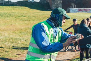 6 Ekim 2018 - Novogrudok, Beyaz Rusya: Castle Road, yarış sırasında çayır üzerinde üniforma duran adam