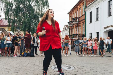 21 Temmuz 2018 - Minsk, Beyaz Rusya: mikrofon standları önünde birçok insan sokakta kadınla