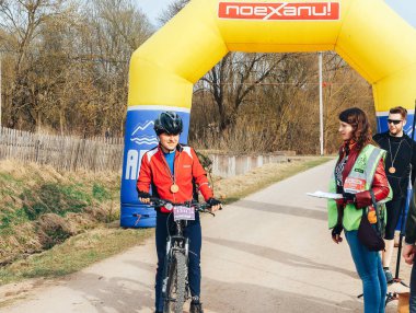 15 Nisan 2018 - Krevo, Beyaz Rusya: Beetle Trail Krevo, Bisiklet ayakta şişme arch yakınındaki adamla