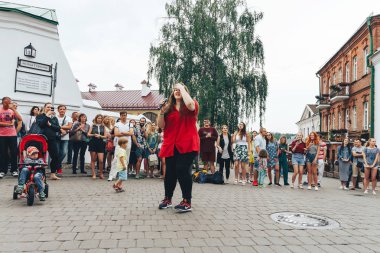 21 Temmuz 2018 - Minsk, Beyaz Rusya: mikrofon standları önünde birçok insan sokakta kadınla