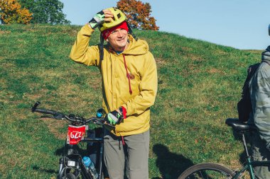 6 Ekim 2018 - Novogrudok, Beyaz Rusya: Kale yolu. yeşil çim arka plan üzerinde duran adam bisiklet ile