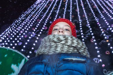 Küçük kız Noel ağacının yanında yeni yıl tatil günlerinde şehir üzerinde kare ayakta