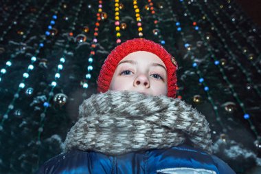Küçük kız Noel ağacının yanında yeni yıl tatil günlerinde şehir üzerinde kare ayakta