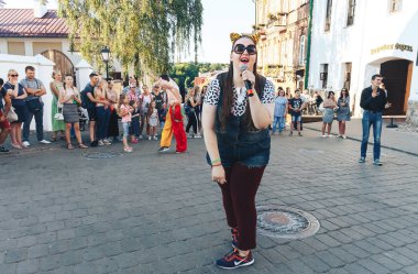 4 Ağustos 2018 - Minsk, Beyaz Rusya: Sokak şenlikleri akşam şehirde. Kadın sokakta mikrofon şarkı