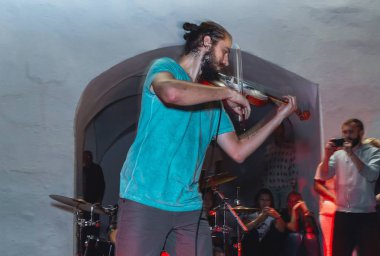 1 Eylül 2018 - Minsk, Beyaz Rusya: Sokak şenlikleri akşam şehirde. adam sokakta insanların önünde oynarken keman ile