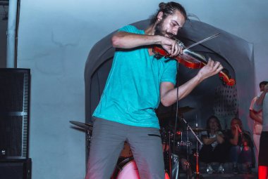 1 Eylül 2018 - Minsk, Beyaz Rusya: Sokak şenlikleri akşam şehirde. adam sokakta insanların önünde oynarken keman ile