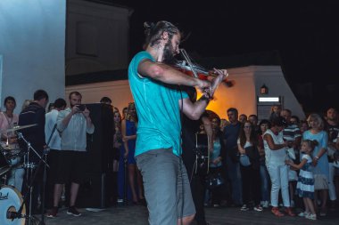 1 Eylül 2018 - Minsk, Beyaz Rusya: Sokak şenlikleri akşam şehirde. adam sokakta insanların önünde oynarken keman ile