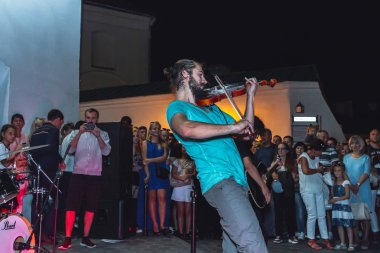 1 Eylül 2018 - Minsk, Beyaz Rusya: Sokak şenlikleri akşam şehirde. adam sokakta insanların önünde oynarken keman ile