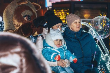 30 Aralık 2018 - Minsk, Beyaz Rusya: kasaba meydanında yeni yıl kutlamaları. Anne ile kızı ve büyükanne parlayan taşıma