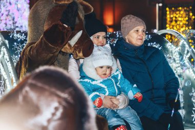 30 Aralık 2018 - Minsk, Beyaz Rusya: kasaba meydanında yeni yıl kutlamaları. Anne ile kızı ve büyükanne parlayan taşıma