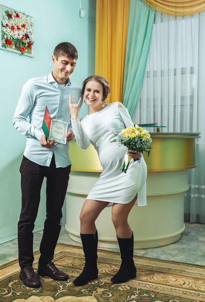 El novio en la camisa y la novia en un vestido blanco con documentos de matrimonio — Foto de Stock