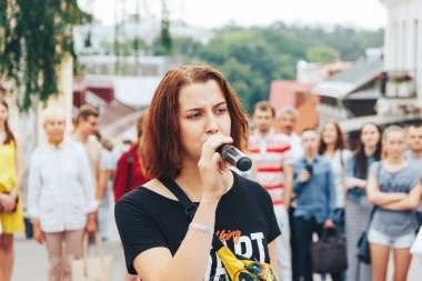 21 Temmuz 2018, Minsk, Beyaz Rusya Street yürüyüş kadın bir mikrofon ile bir sokak konserde söylüyor