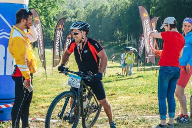 26-27 Mayıs 2018 Naliboki,Belarus Tüm Belarus amatör maratonu Naliboki Bisikletli bir adam finişte madalyalı duruyor