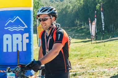 26-27 Mayıs 2018 Naliboki,Belarus Tüm Belarus amatör maratonu Naliboki Bisikletli bir adam finişte madalyalı duruyor